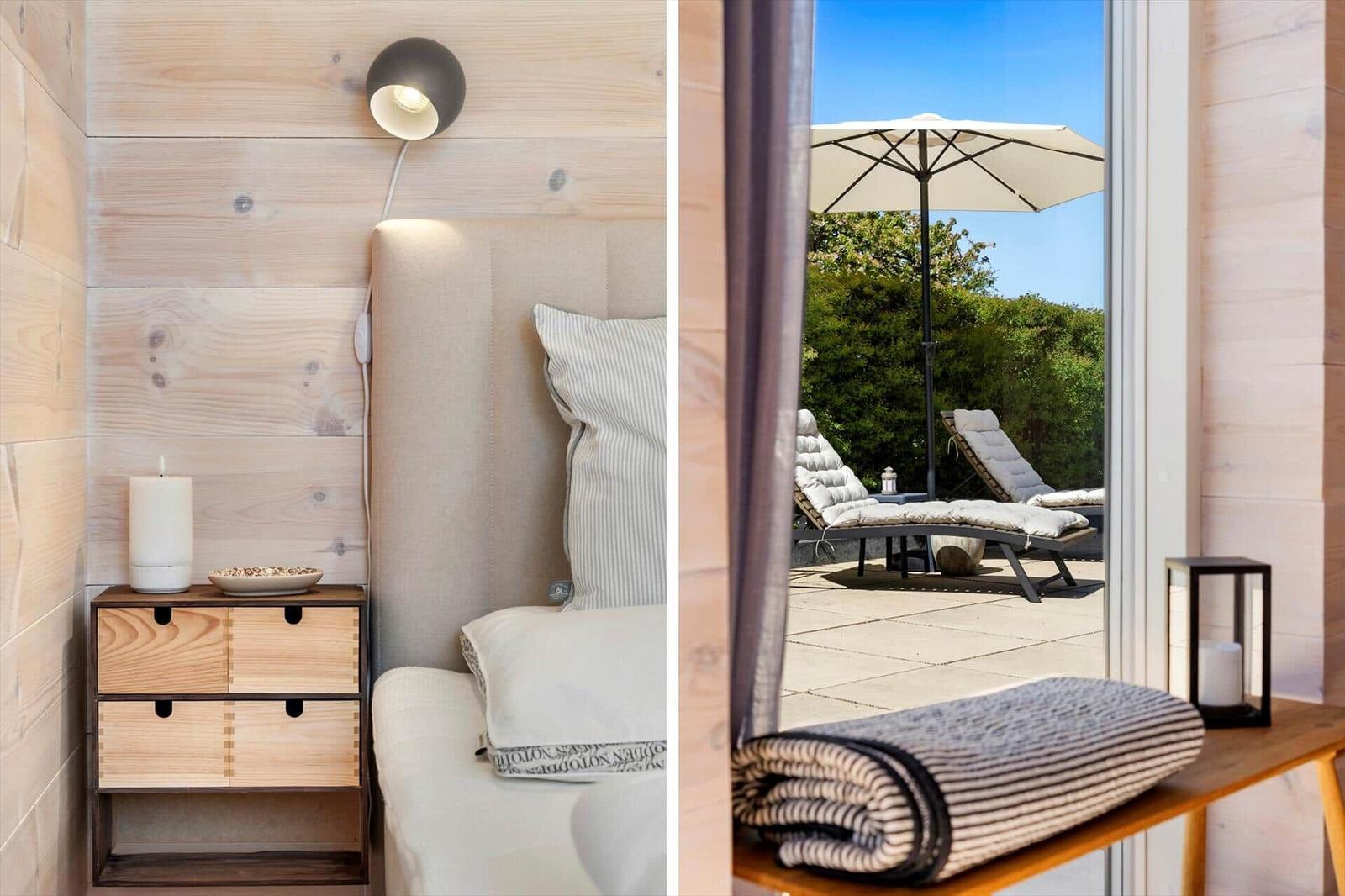 Bedroom with wooden wall and nightstand. Terrace with loungers and umbrella.