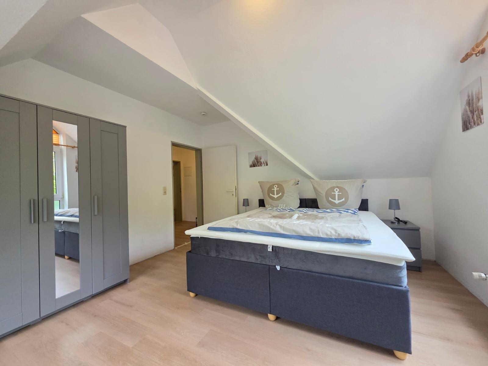Bedroom with double bed, wardrobe, and sloped ceiling.