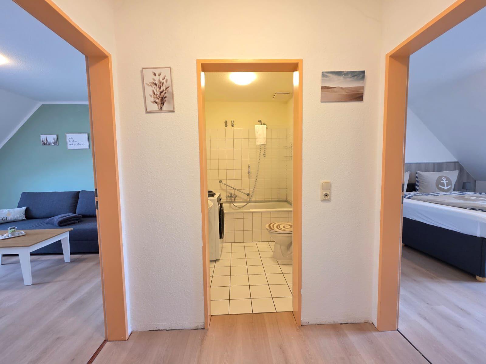 Bathroom with bathtub and shower. Left living room, right bedroom with bed.