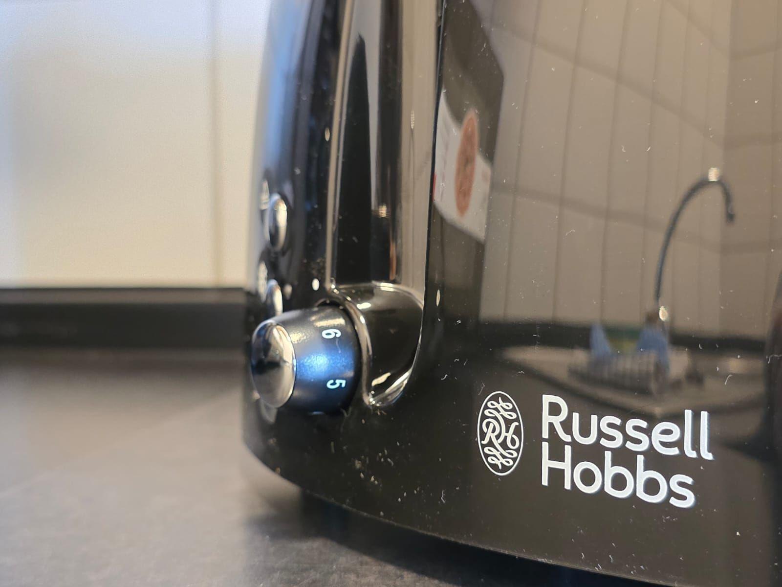 Black toaster with dial knob and brand logo on countertop.