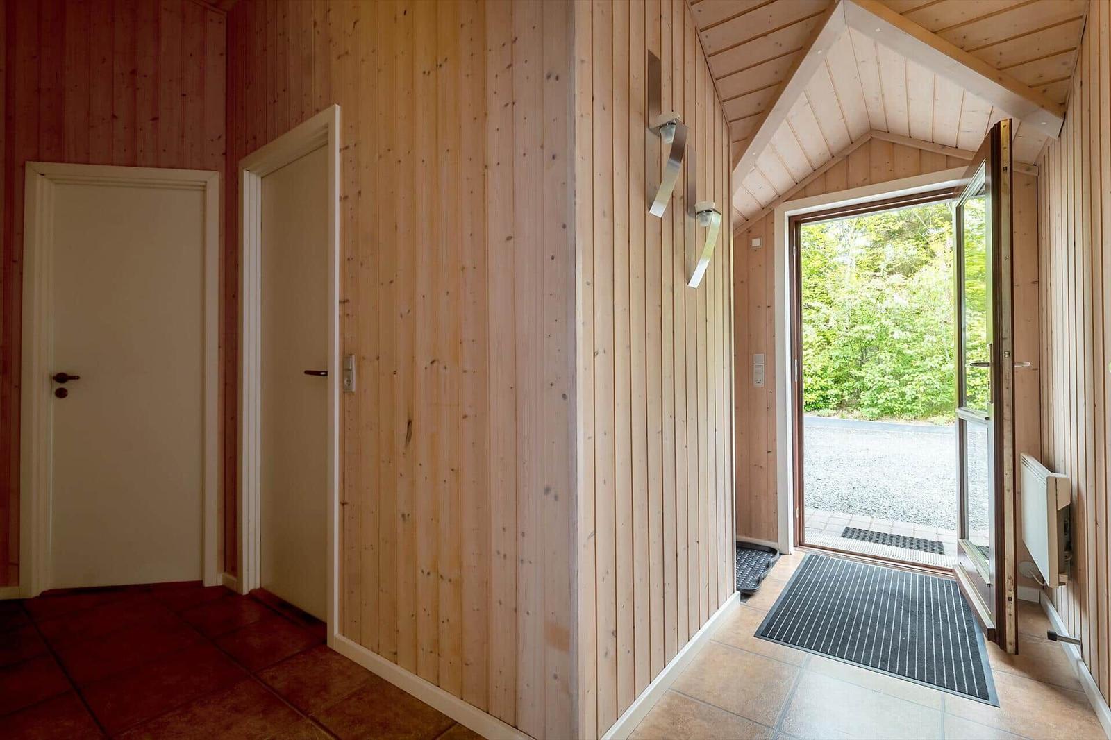 House with wooden walls, door, and glass door to the garden
