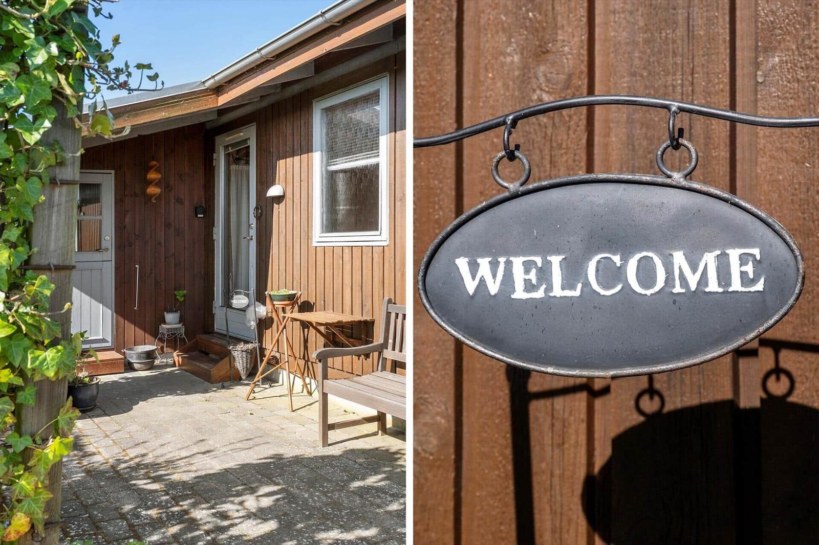 Wooden house with entrance area and welcome sign on the wall