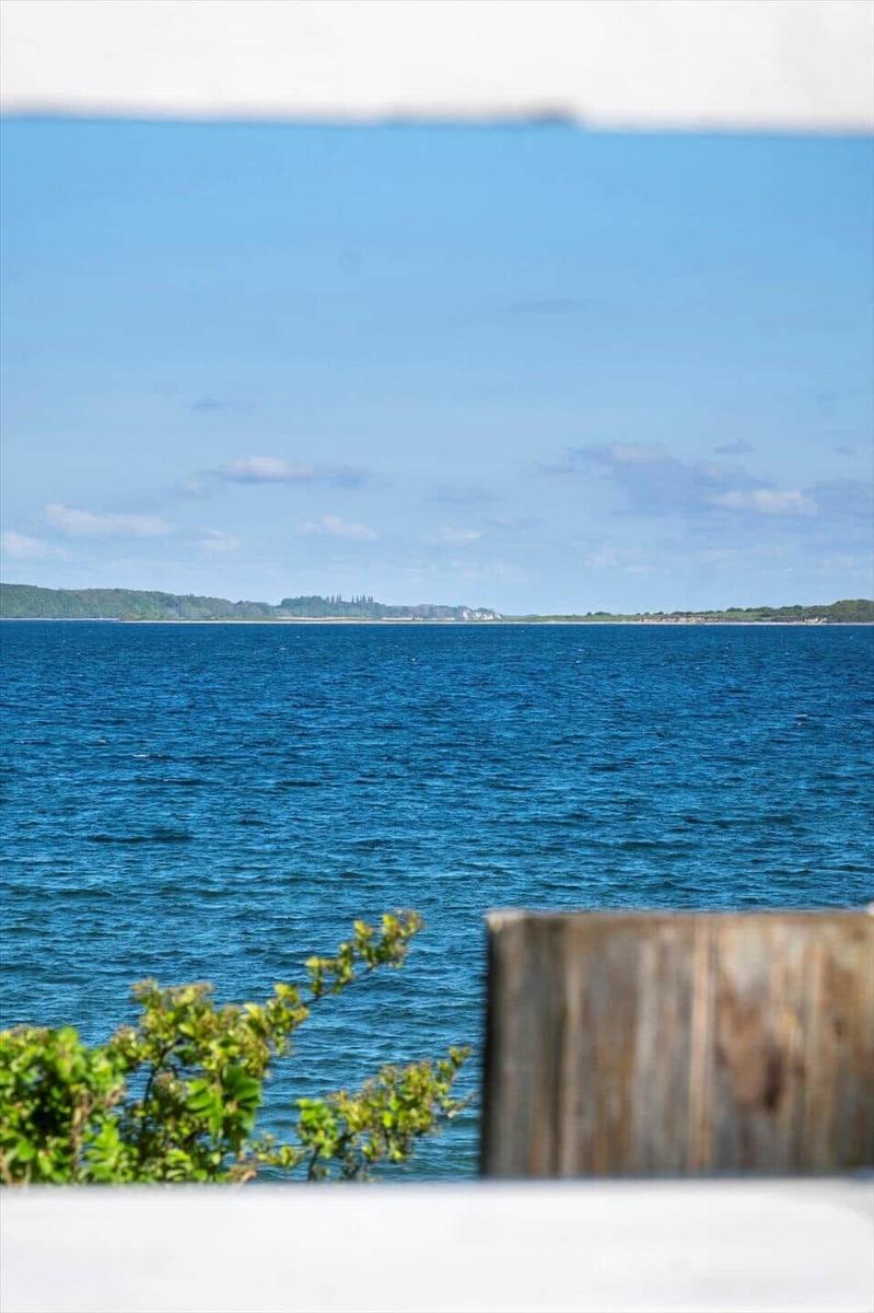 View of the sea with green landscape in the background.