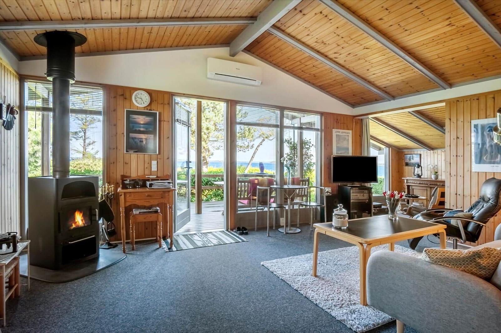 Living room with fireplace, large windows, and view of the lake.