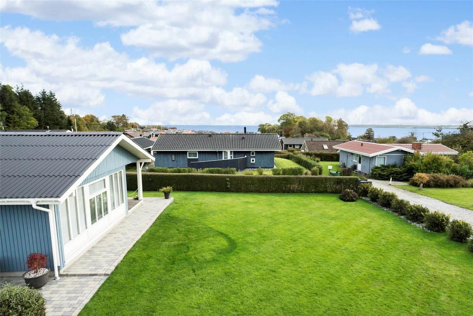 Ein Haus mit großem Garten und Blick aufs Wasser.