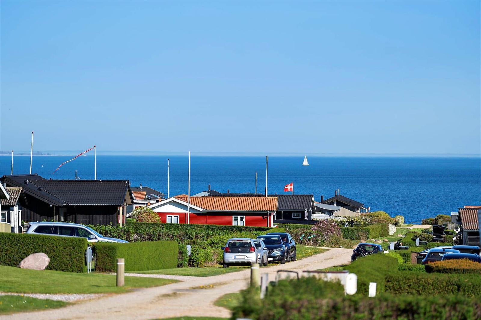 Strandnahe Häuser mit Blick auf das Meer und Segelyachten.