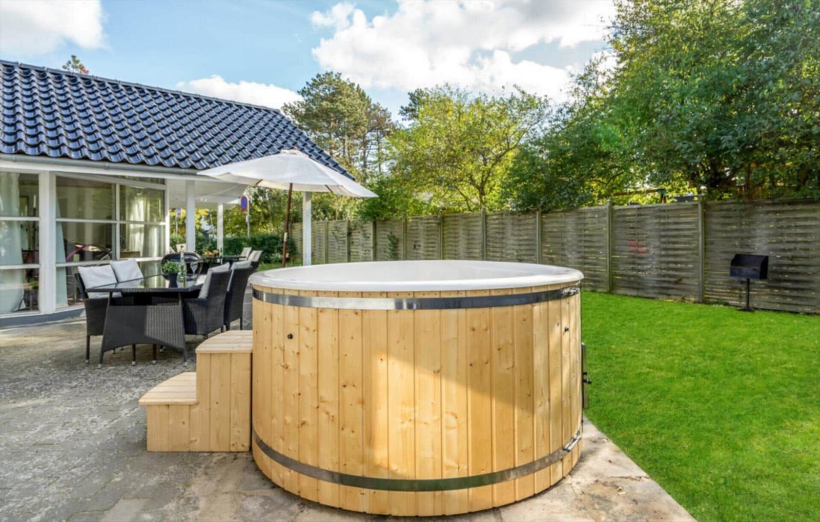 House with garden, hot tub, and seating area.