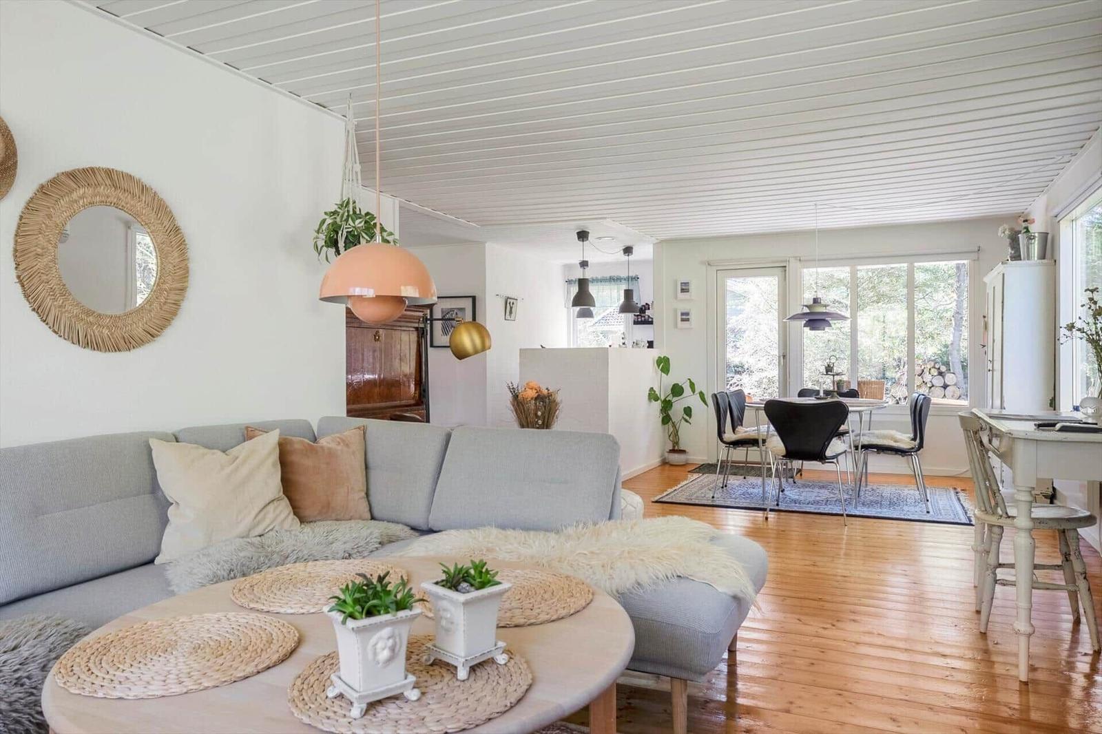 Living and dining area with sofa, table, chairs, and wooden floor.