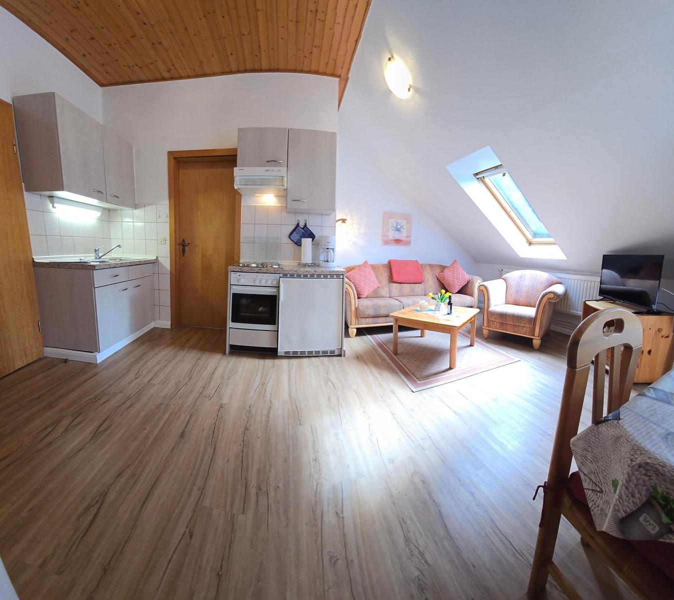 Wohnung mit Küche, Wohnzimmer und Schlafbereich unter Holzdach