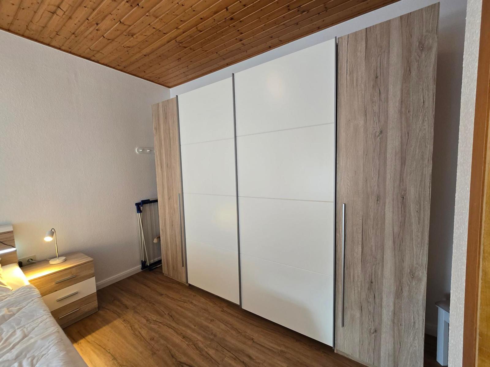 Schlafzimmer mit Kleiderschrank, Nachttisch und Bett