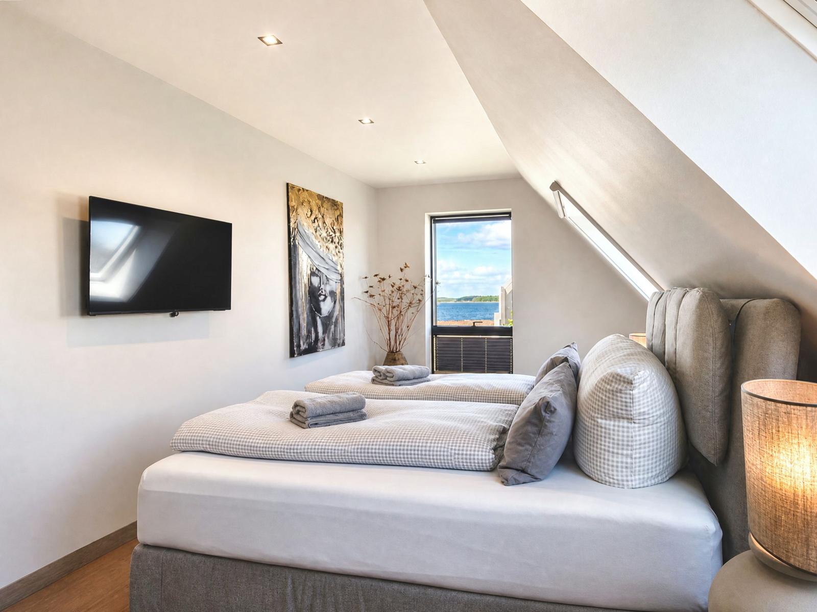 Bedroom with bed, TV, and view of water