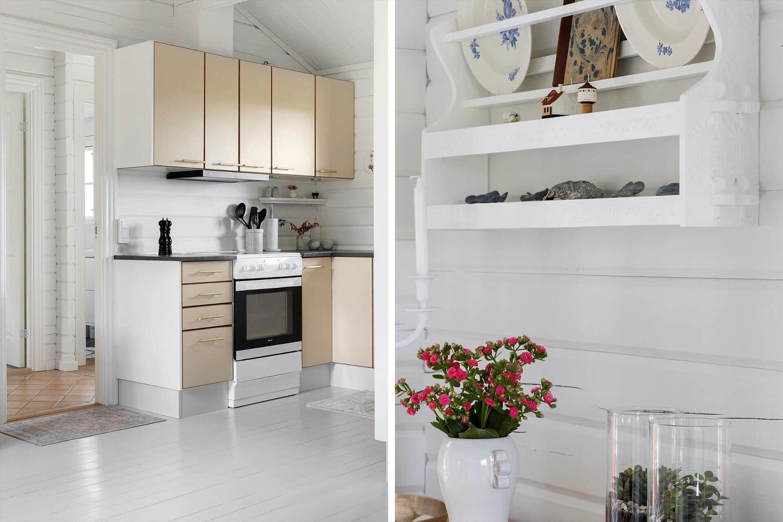 Kitchen with light cabinets and white walls. Decoration with flowers and plates.