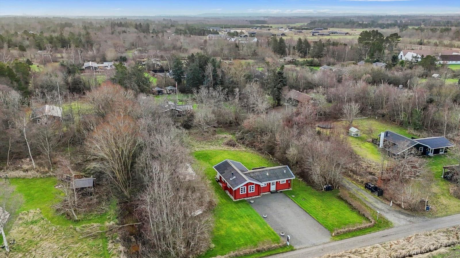 Red house with garden and forest, view of rural surroundings