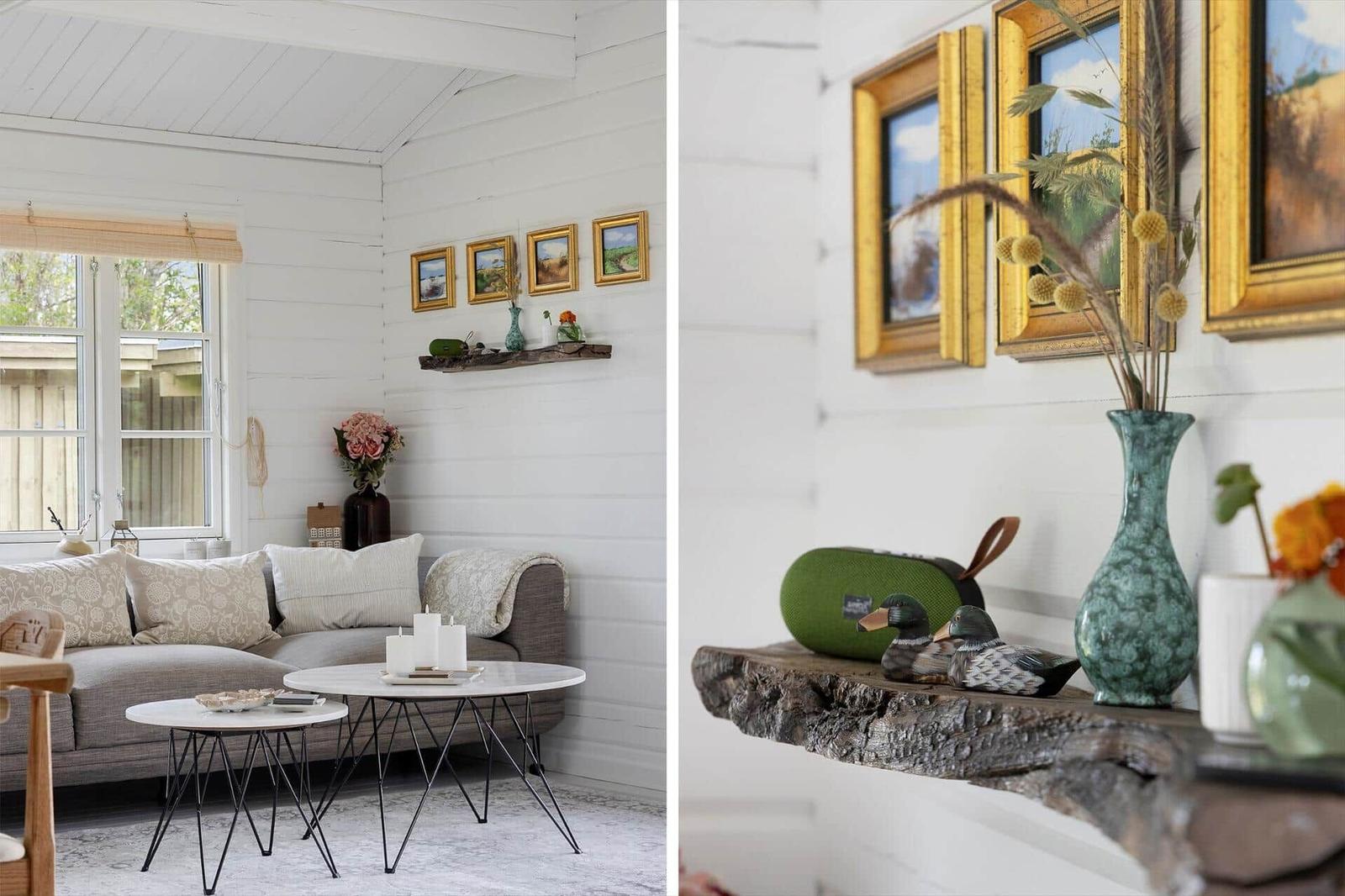 Living room with sofa, tables, and wall pictures. Wooden shelf with vases and decor.