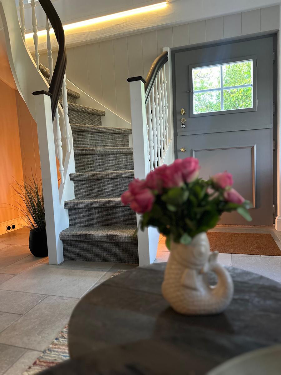 Haus mit Treppe, Eingangstür und Blumen auf Tisch