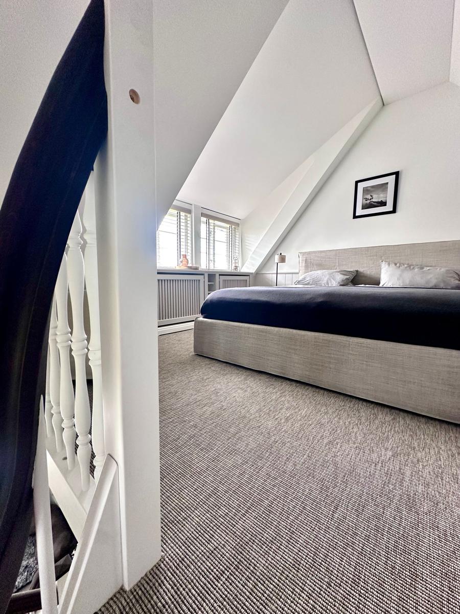 Schlafzimmer mit Dachschrägen, Bett und Fenster