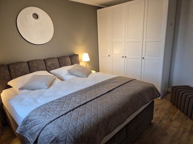 Schlafzimmer mit Bett, Kleiderschrank und Wanddekoration.