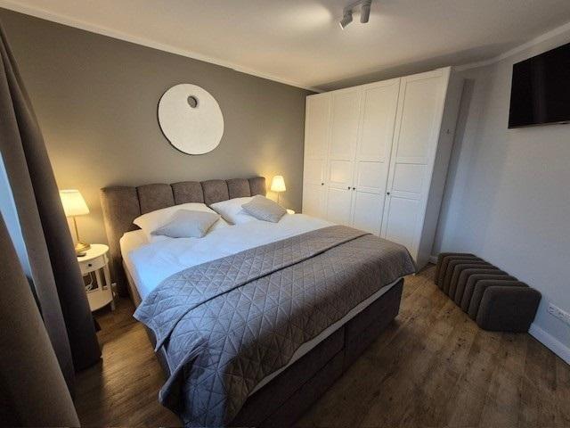 Schlafzimmer mit Doppelbett, Kleiderschrank und Wandbild