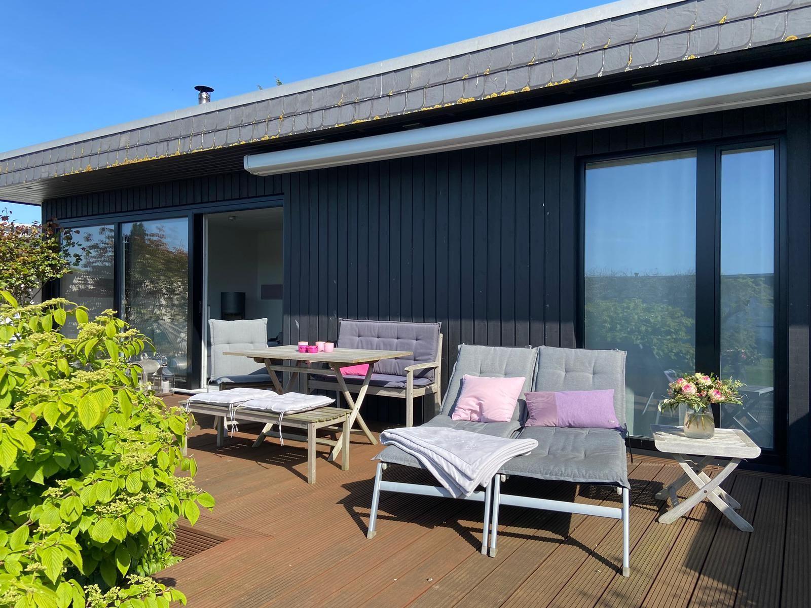 Liegen und Gartenmöbel auf der großen Holzterrasse