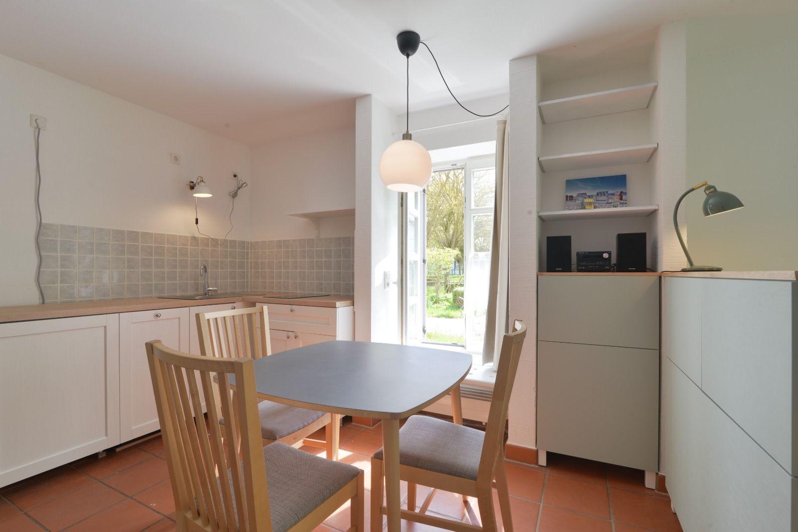Küche mit Esstisch, Fenster und Regal