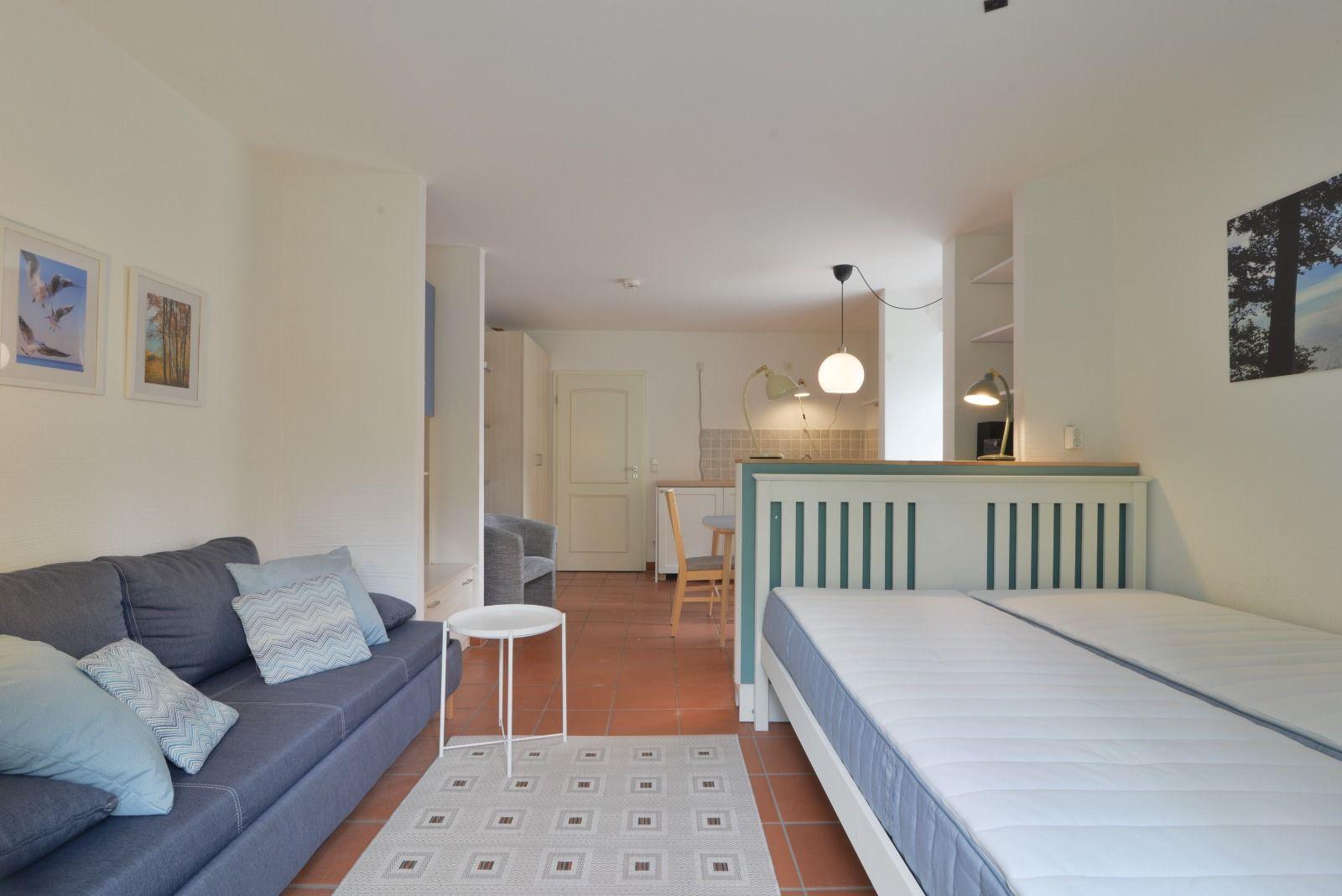Ein Schlafzimmer mit zwei Matratzen und einem Sofa im Wohnbereich.