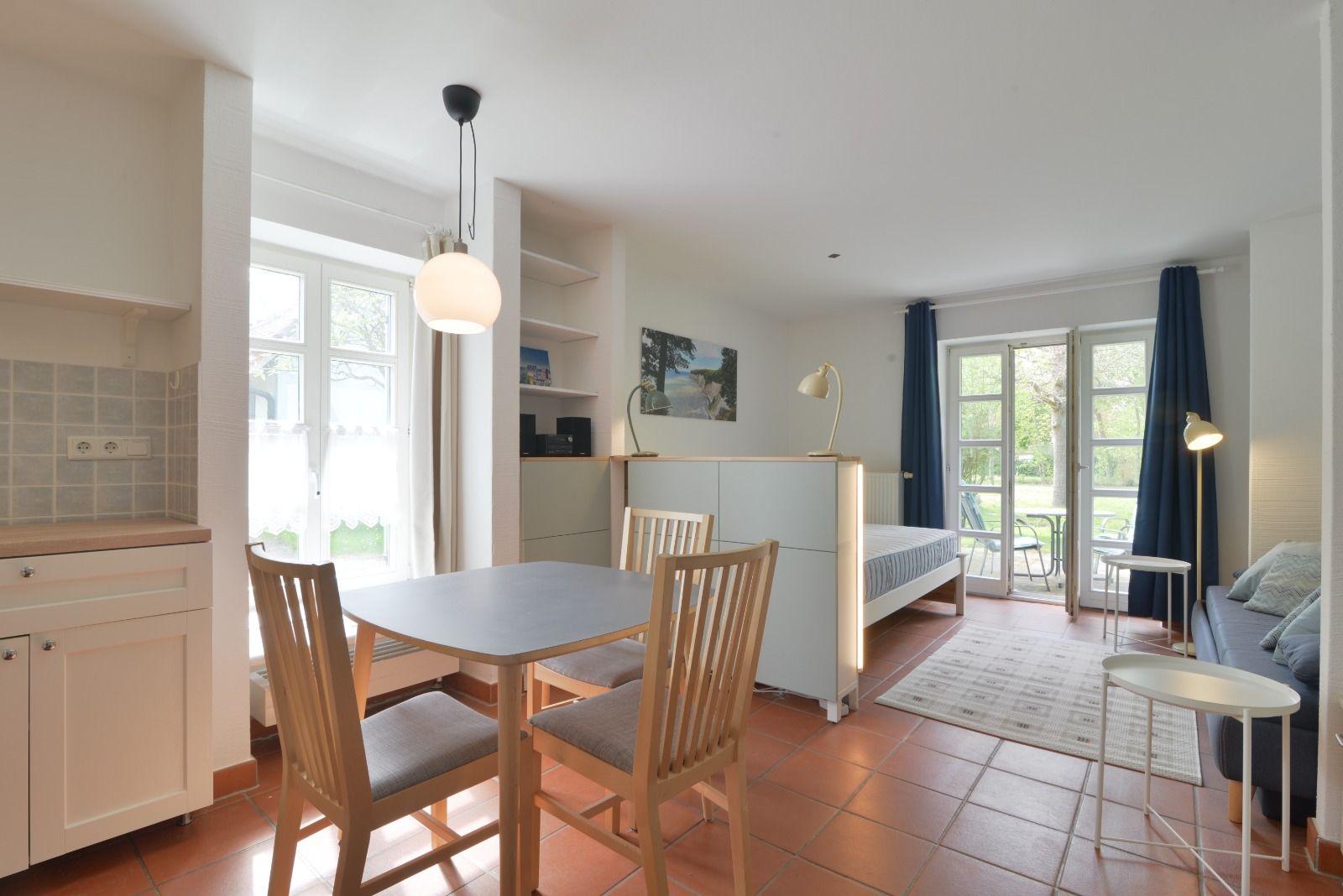 Wohn- und Essbereich mit Schlafplatz, Terrasse und Küchenzeile.