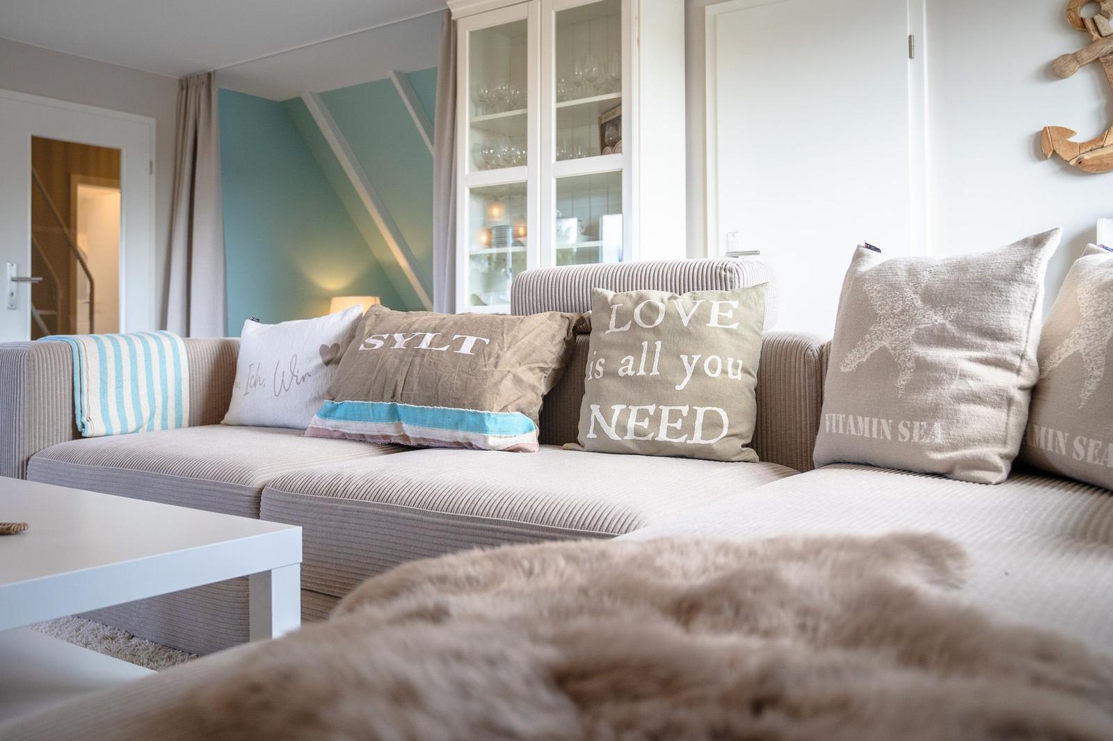 Ein Sofa mit Kissen und einer Decke im Wohnzimmer.
