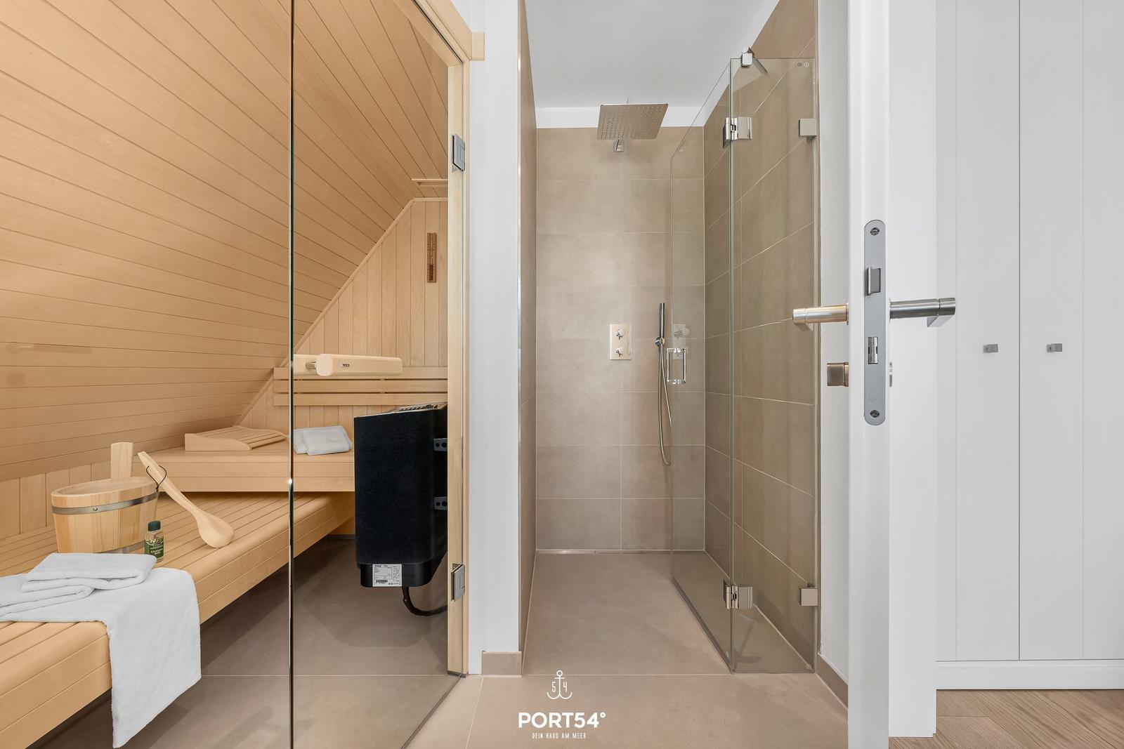 Sauna with wooden benches and shower with glass wall