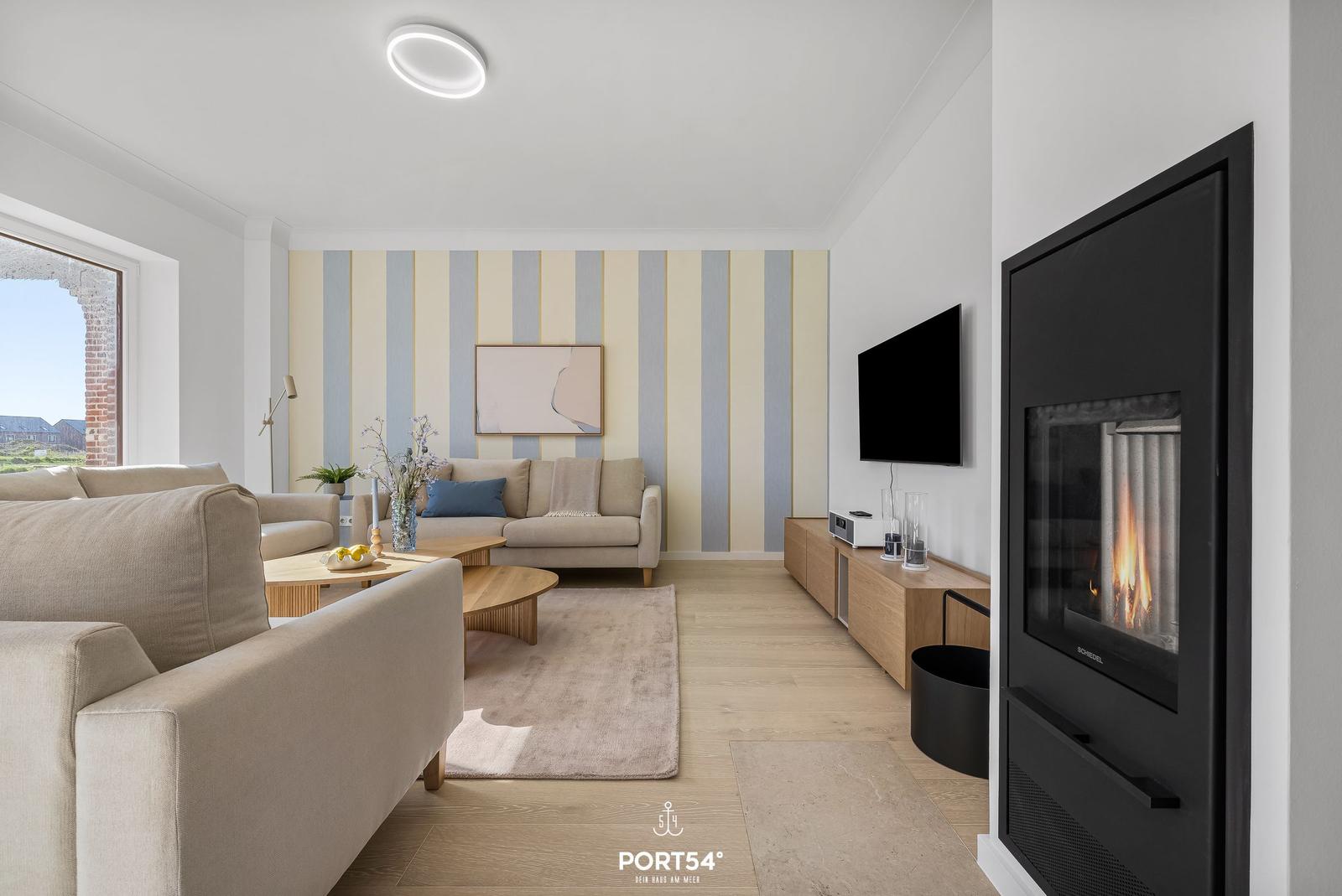 Living room with sofa, fireplace, and TV mounted on the wall.