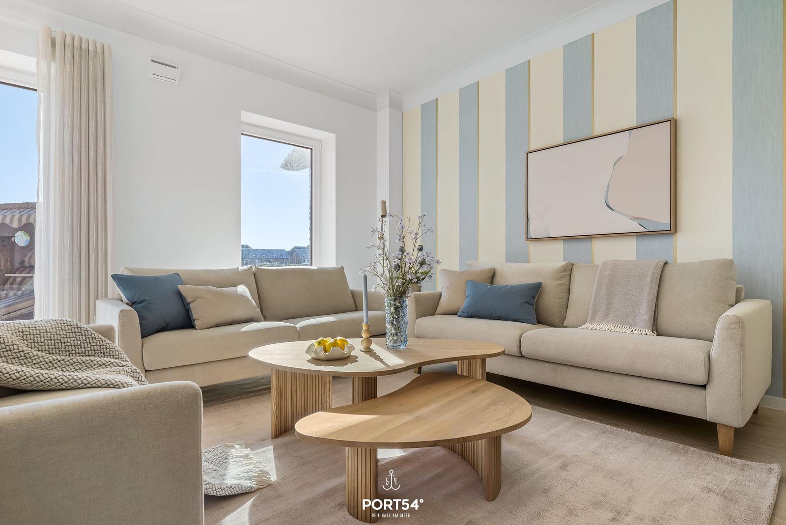 Living room with two sofas, wooden table, and striped wall.