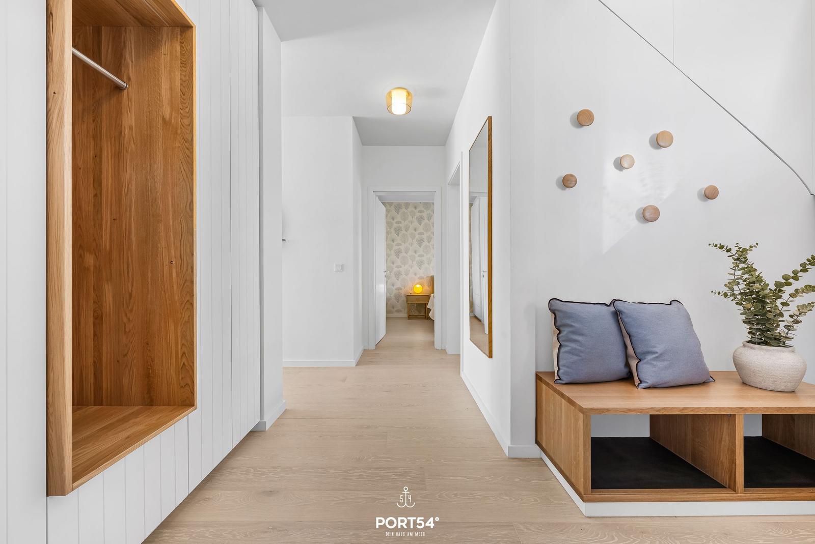Hallway with wooden closet, bench, and wall decor.