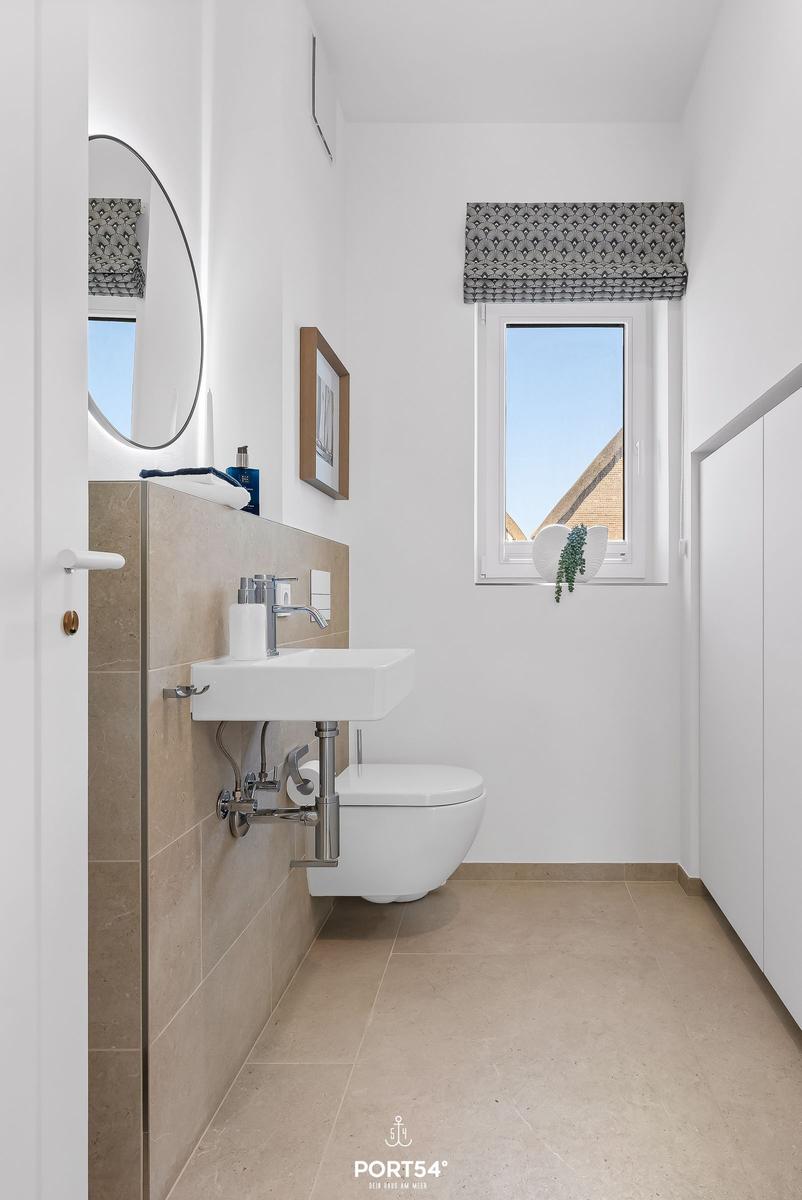 Bathroom with sink, toilet, and window.