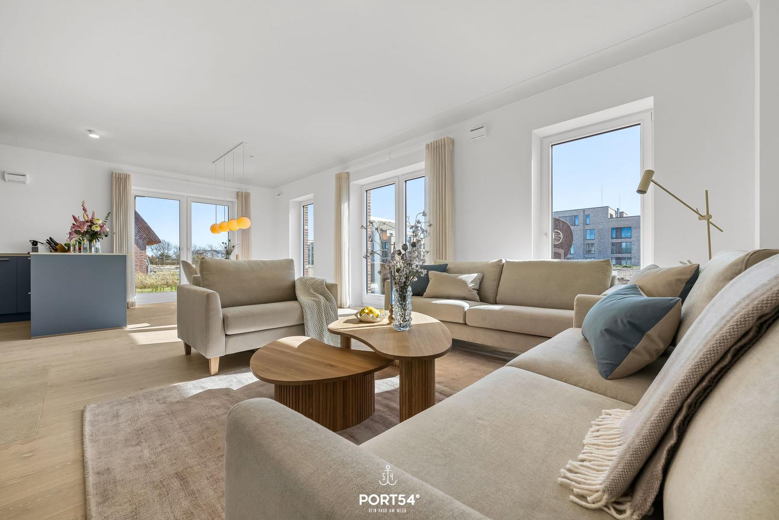 Living area with sofa, coffee table, and windows for views.