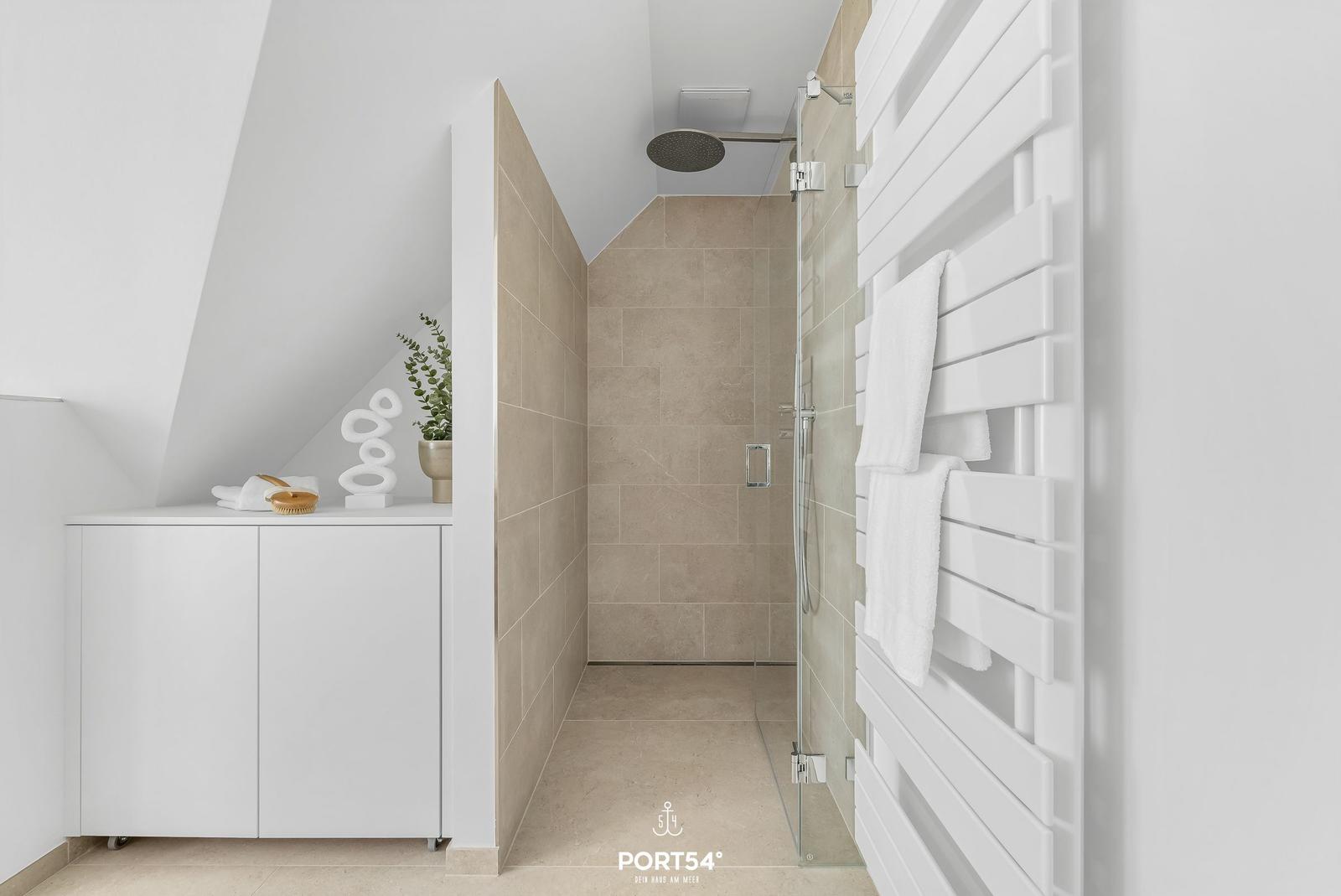 Shower with showerhead, towel rack, and bathroom furniture