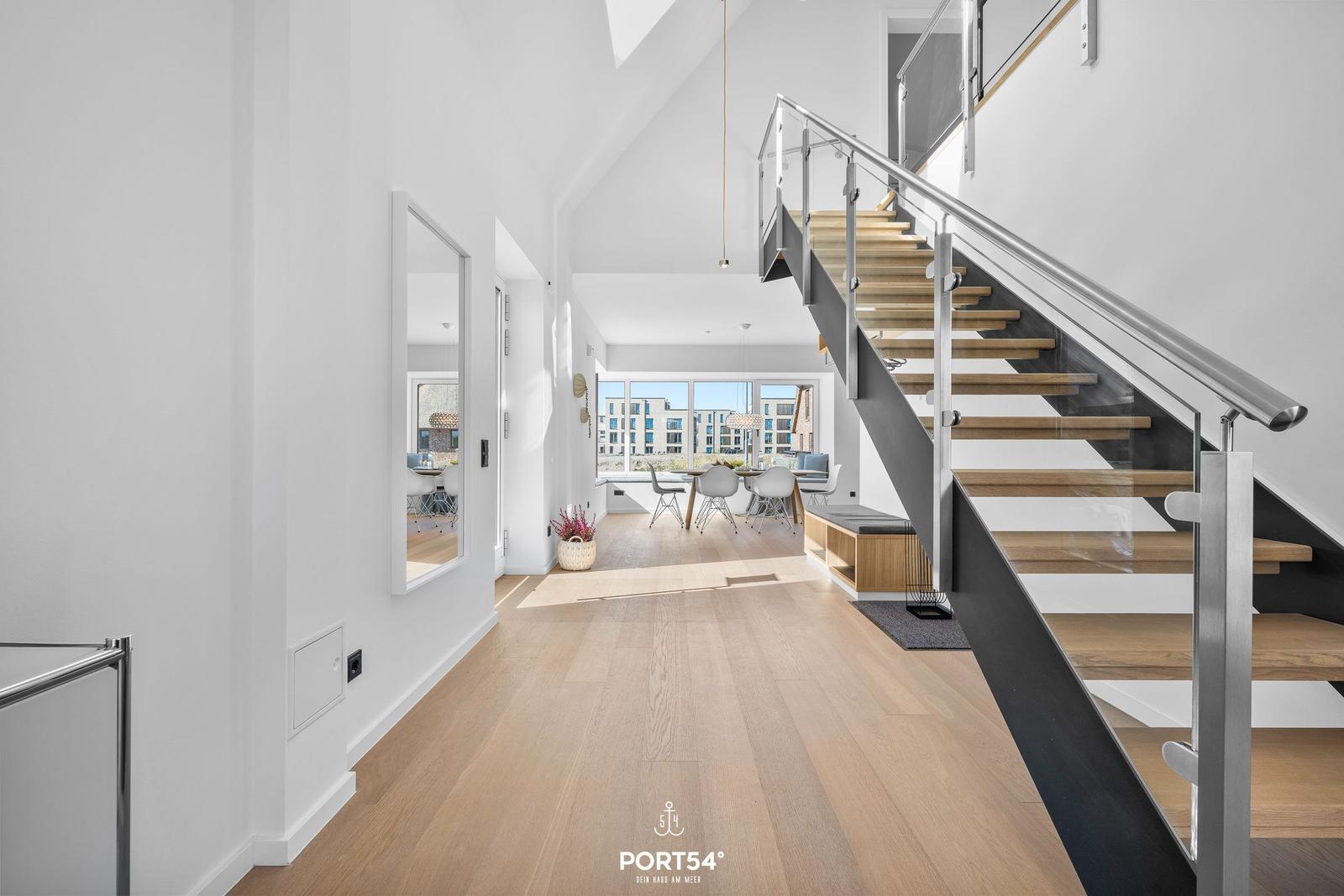 Haus mit Holzboden, Treppe und Essbereich mit Blick auf Gebäude.