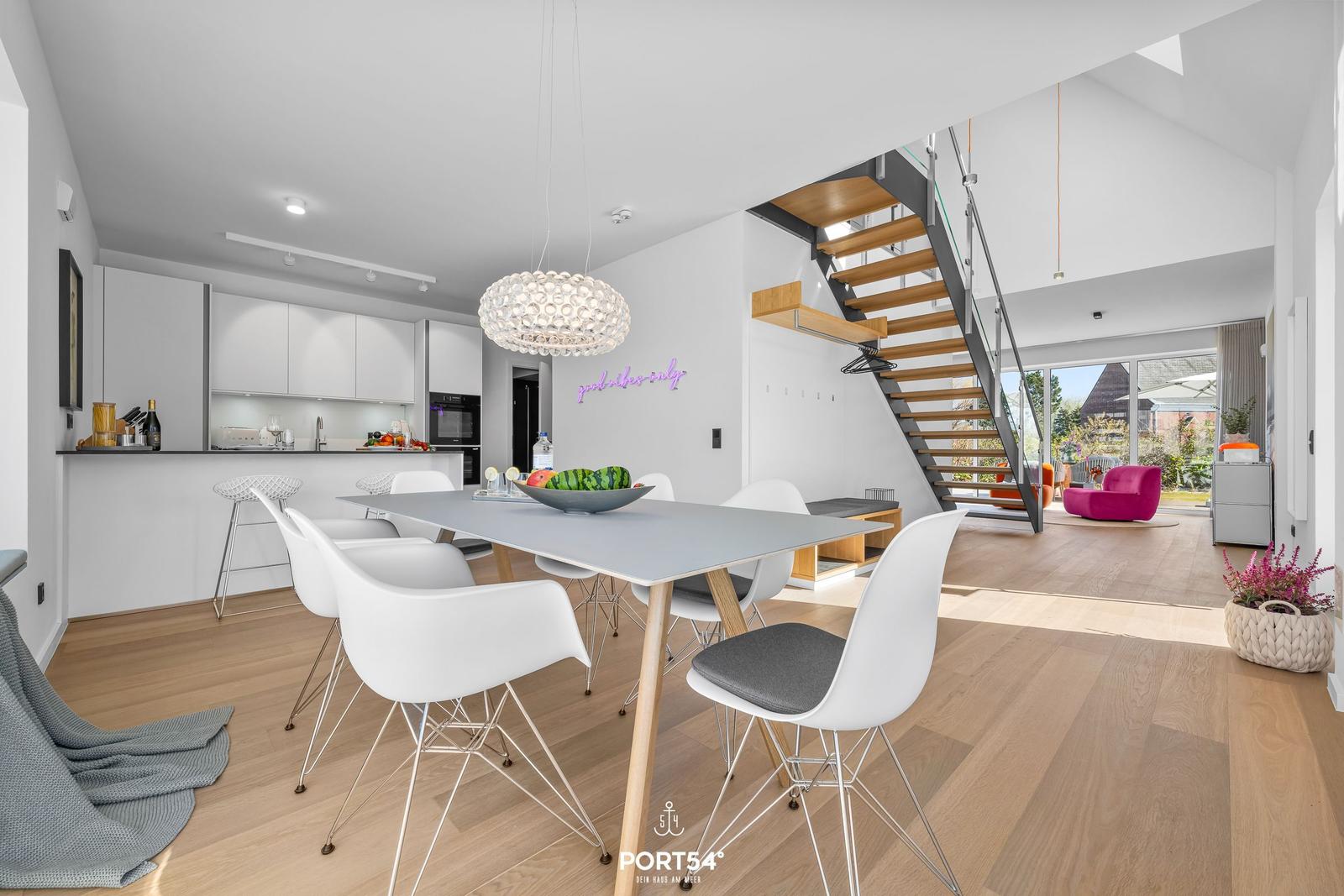 Moderne Küche mit Essbereich und Treppe zur oberen Etage.