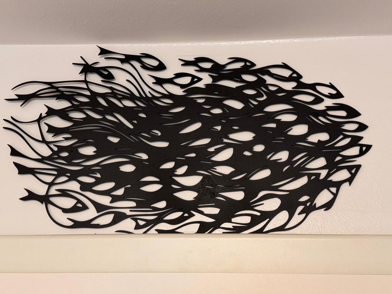 Schwarzes Metallbild mit Fischmotiven an der Wand