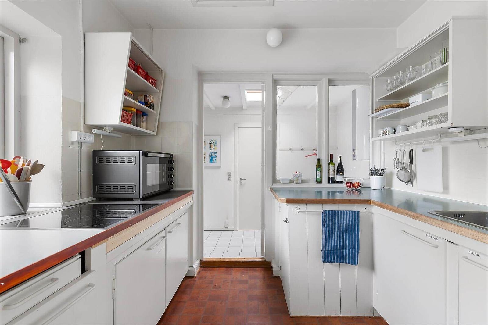 Kitchen with white cabinets, wooden surfaces, and kitchen appliances.