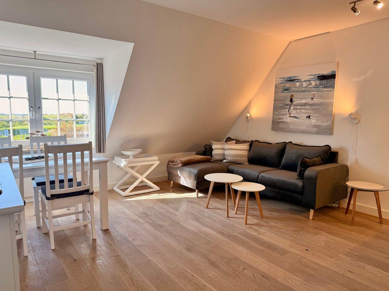 Wohnbereich mit Sofa, Tischen und Fenster mit Blick.