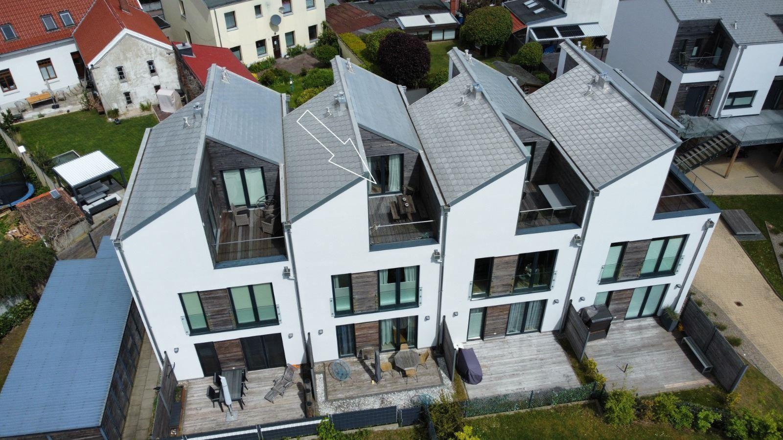 Moderne Mehrfamilienhaus mit Balkonen und Terrassen. Holz- und Glasdetails.