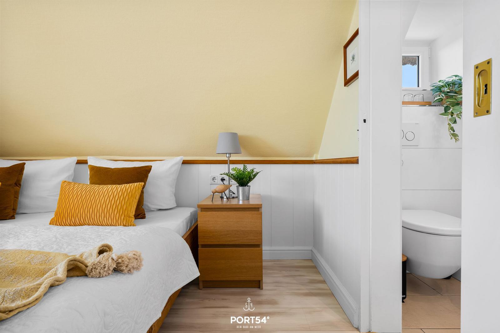 Bedroom with bed, nightstand, and attached bathroom.