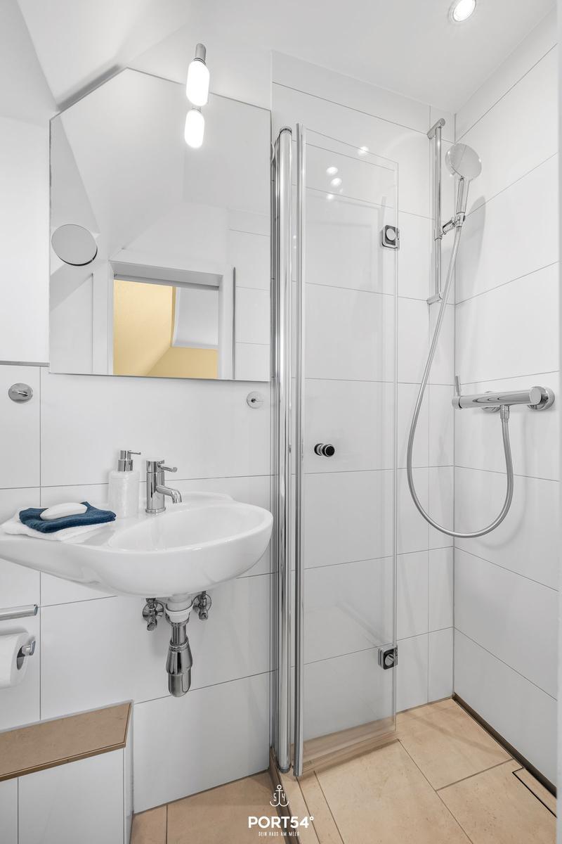 Bathroom with shower, sink, and mirror