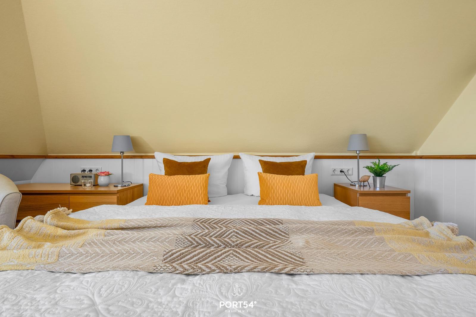 Bedroom with double bed, two nightstands, and decorative pillows.
