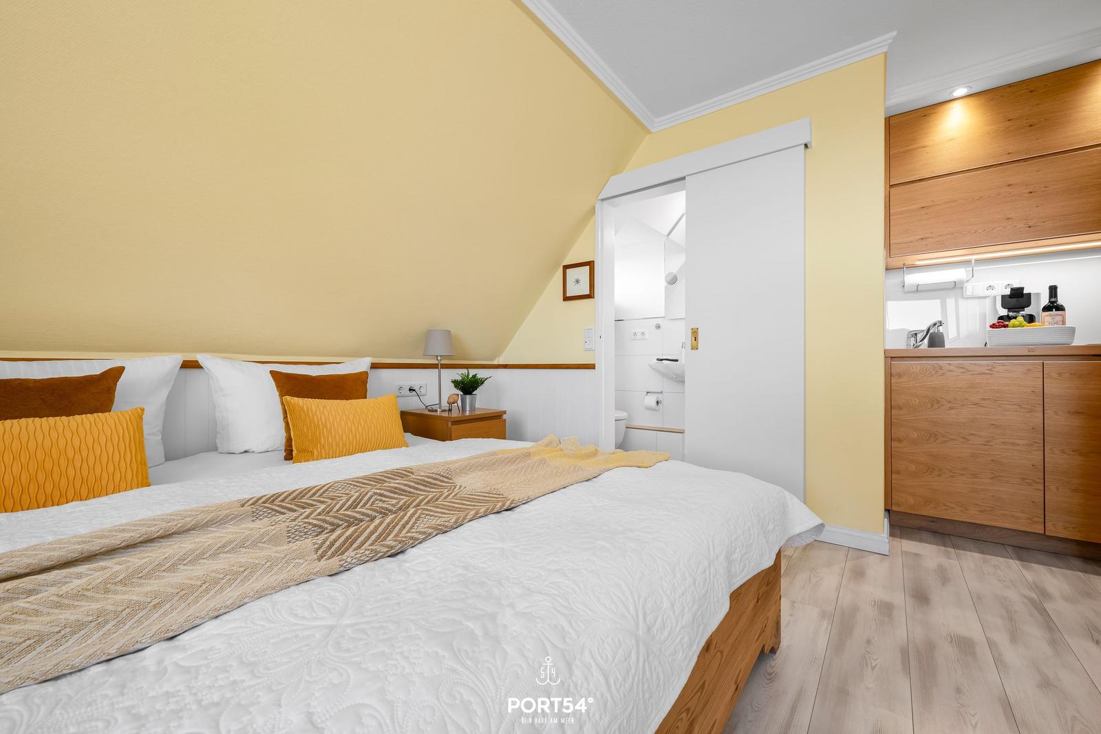 Bedroom with double bed, kitchen area, and bathroom.