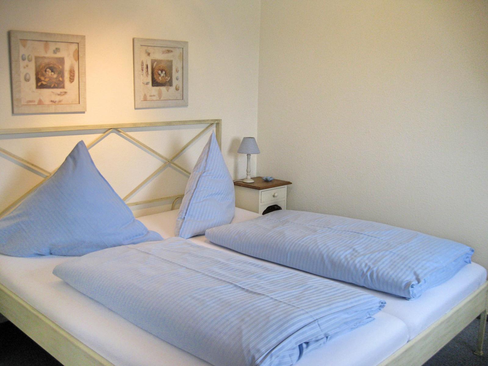 Schlafzimmer mit Doppelbett (180x200), Kleiderschrank und Safe, sowie eine zusätzliche Sitzgelegenheit.