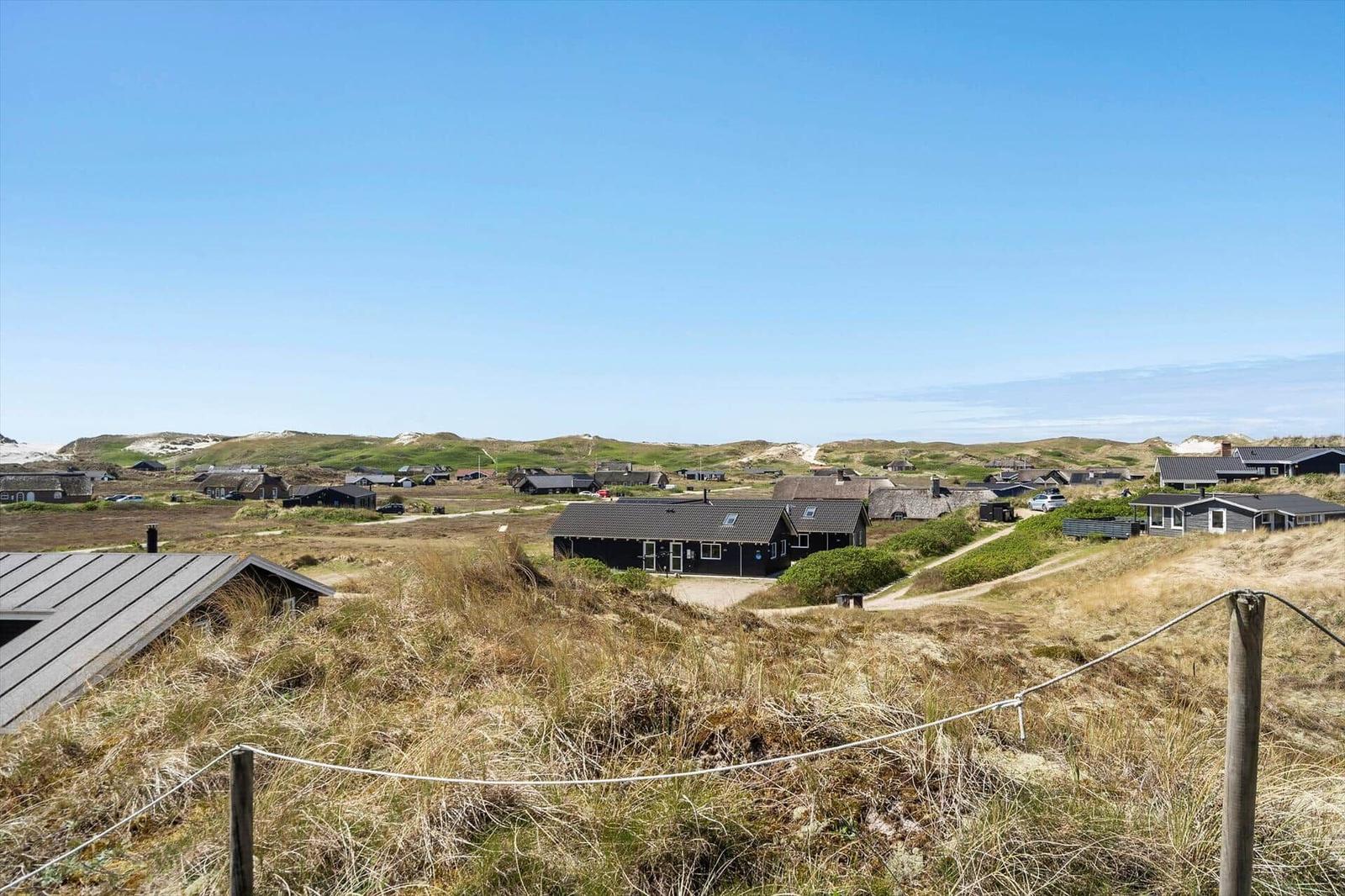 Dorfhäuser auf Dünen unter blauem Himmel