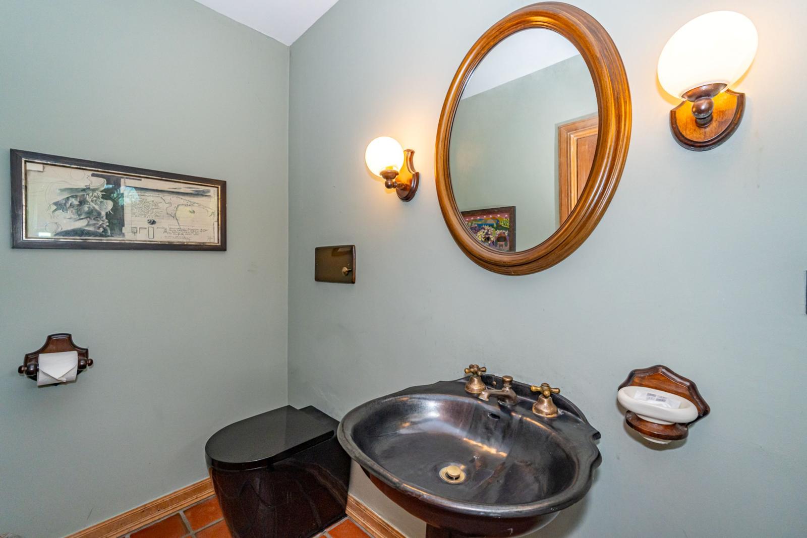 Badezimmer mit Waschbecken, Spiegel und Wandbeleuchtung