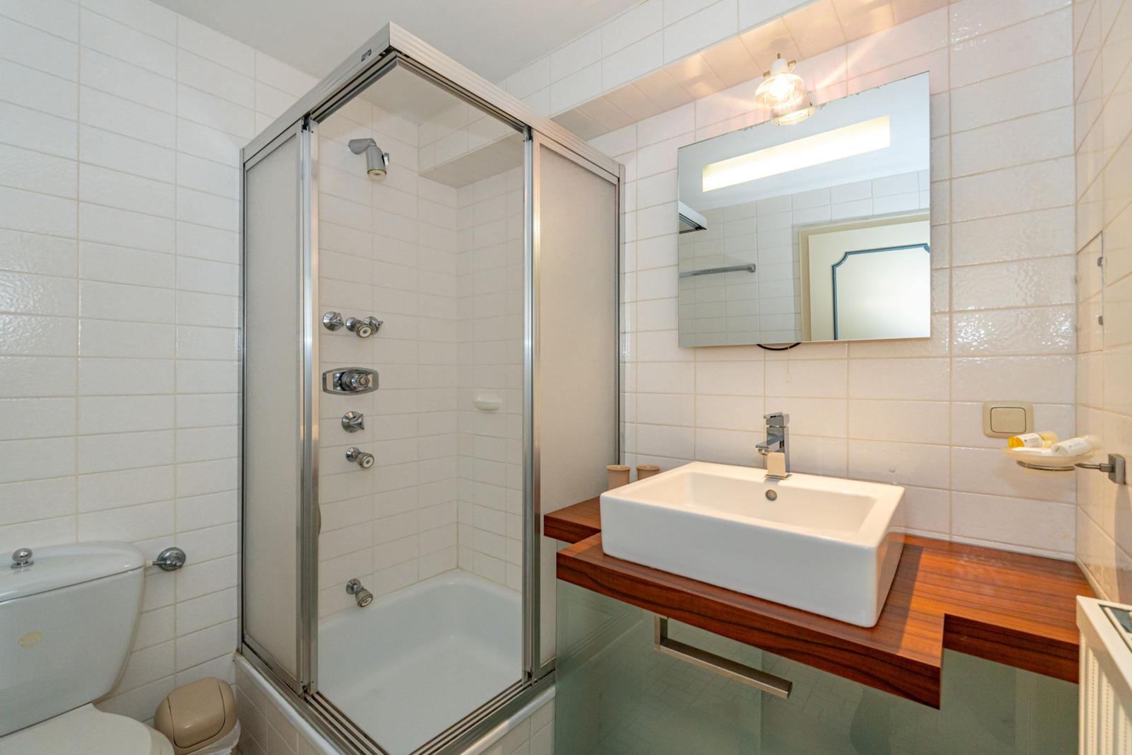 Badezimmer mit Dusche, Waschbecken und Toilette.