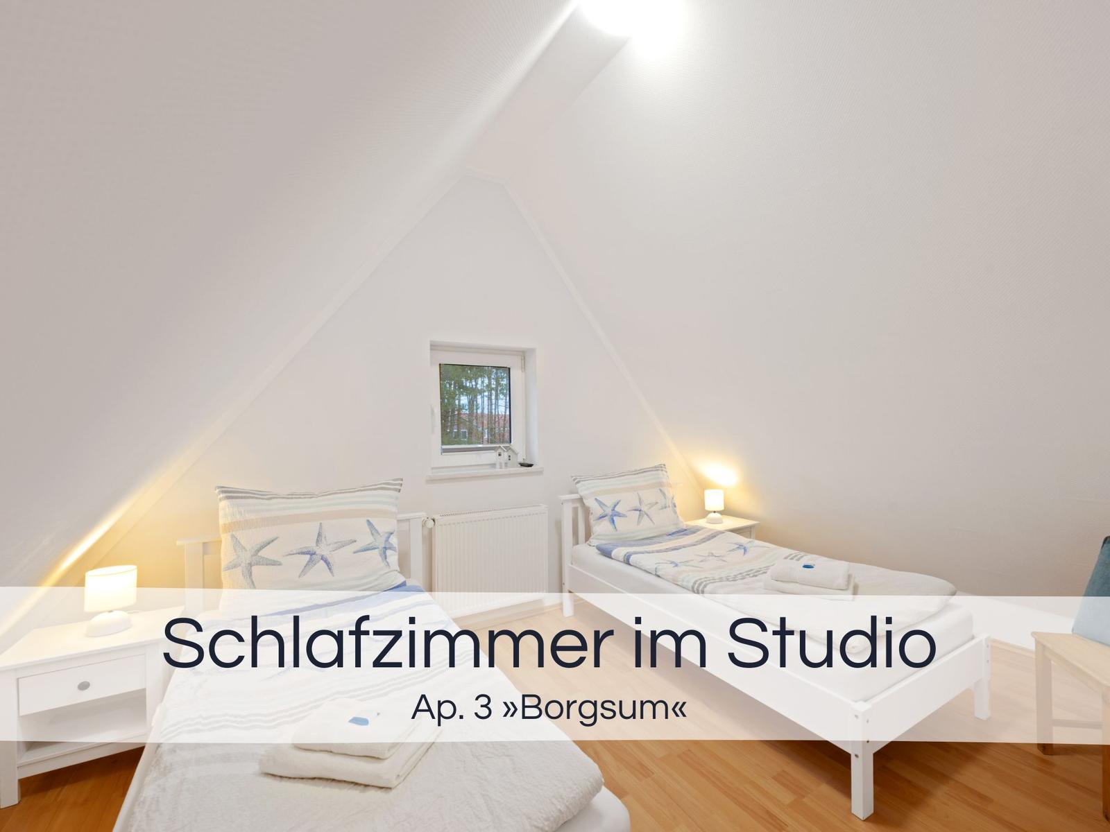 Zwei Betten mit Starfish-Bettwäsche, kleines Fenster, weiße Nachttische und Holzboden.