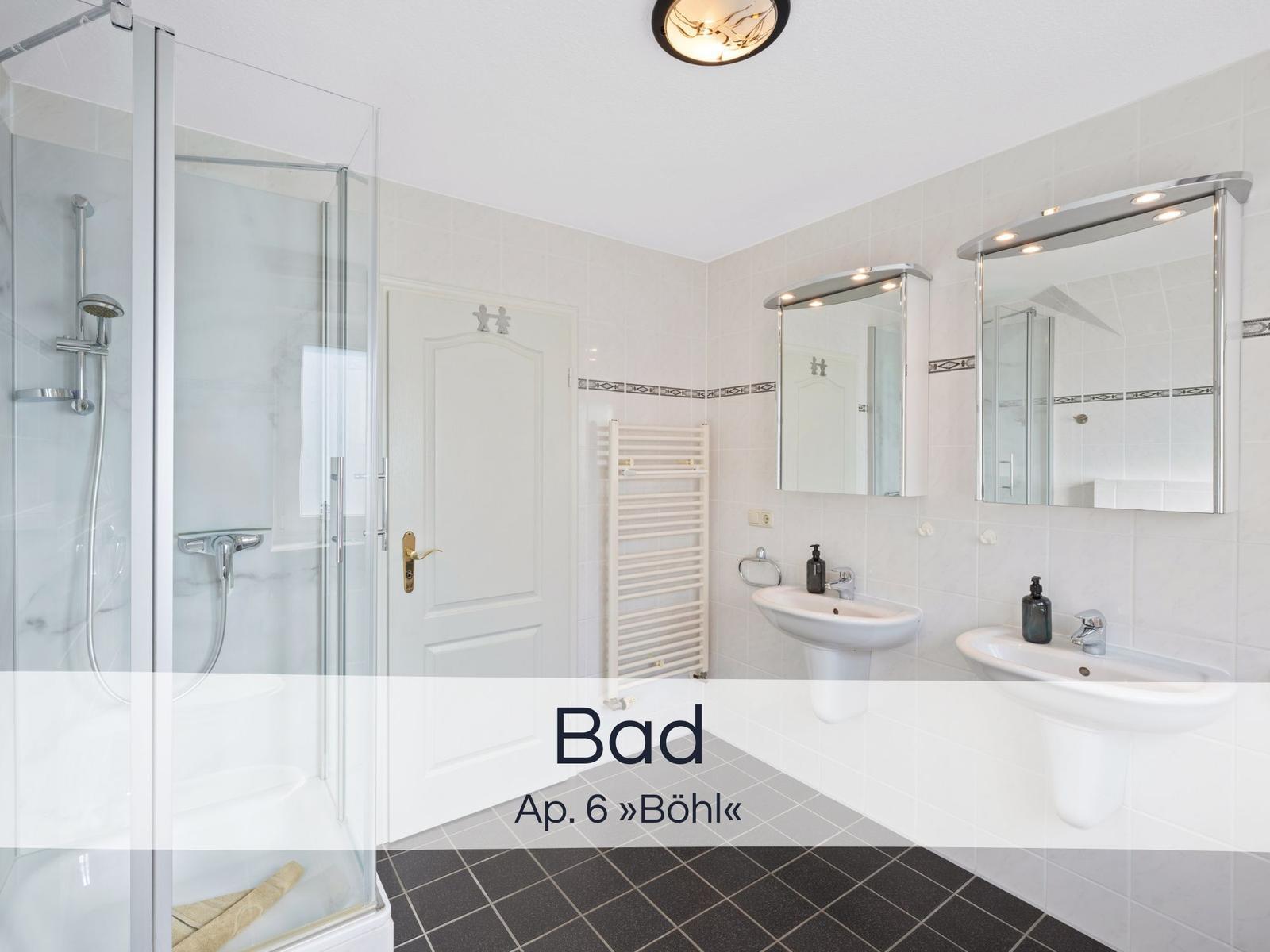 Badezimmer mit Dusche, zwei Waschbecken und Spiegeln.